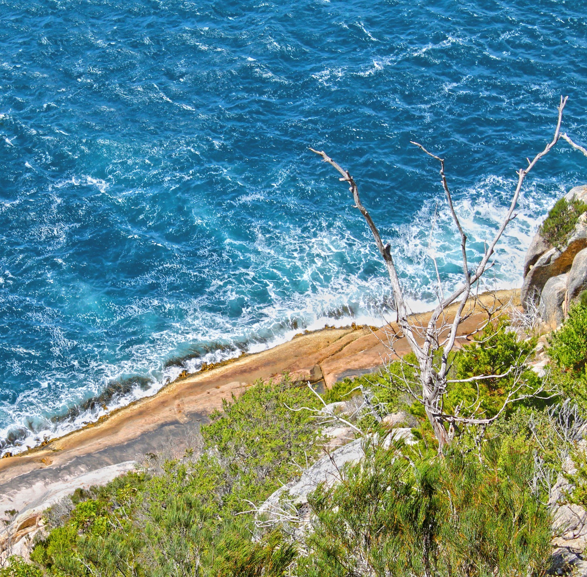 Looking down from Cape Tourville over granite cliffs and deep blue water at Freycinet