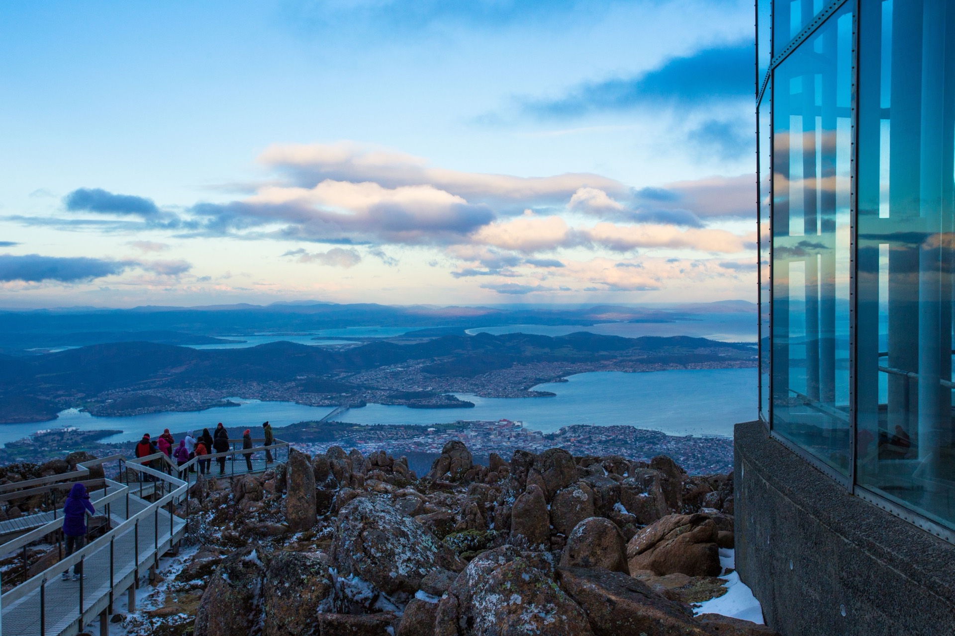 Hobart and the Derwent from the kunanyi / Mount Wellington lookout, with snow among the summit rocks